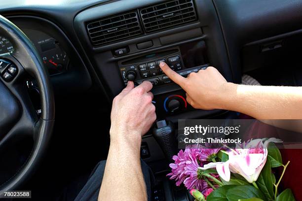 close-up of two hands pressing buttons to adjust the car stereo. - auto radio stockfoto's en -beelden