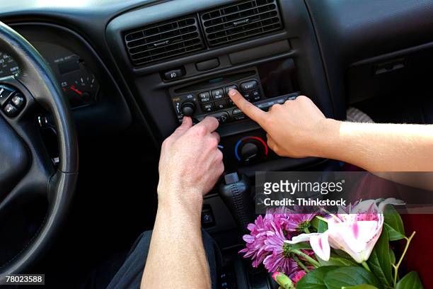 close-up of two hands pressing buttons to adjust the car stereo. - car listening to music imagens e fotografias de stock
