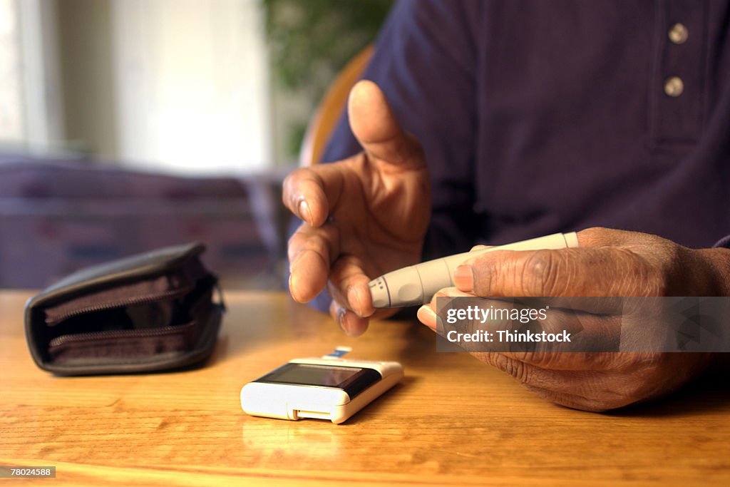 Hands drawing blood for glucose test