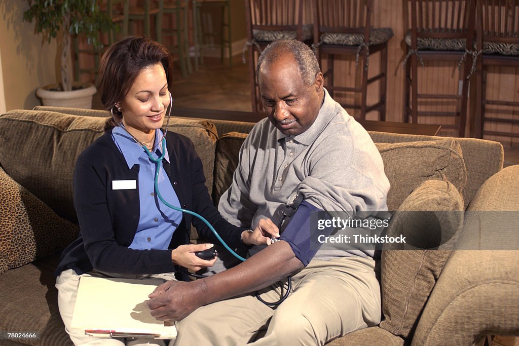 Nurse checking blood pressure of patient