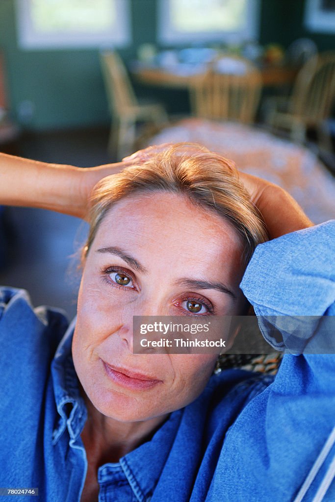 Portrait of woman with hands behind head