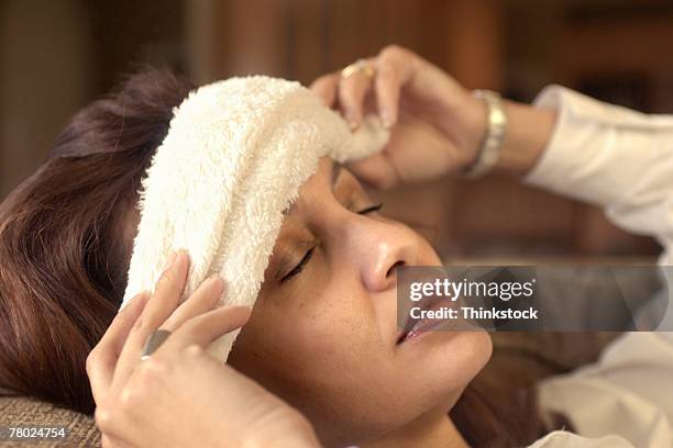 woman with cloth on forehead - lappen stock-fotos und bilder