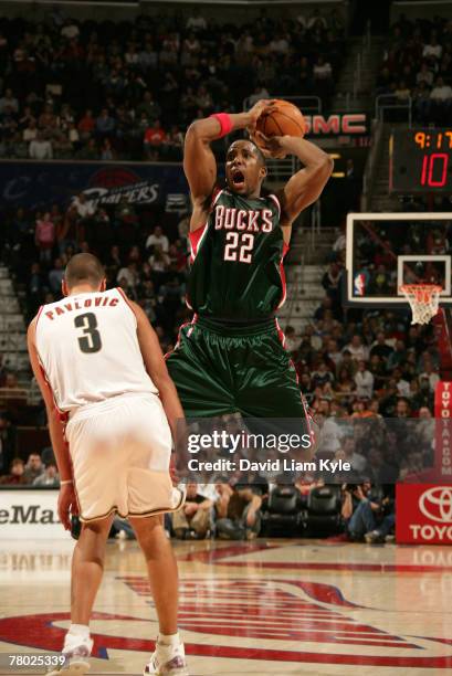 Michael Redd of the Milwaukee Bucks looks to pass after trying to draw the foul against Sasha Pavlovic of the Cleveland Cavaliers on November 20,...