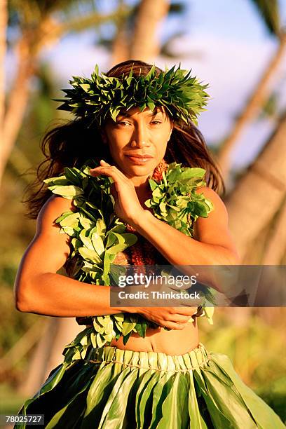 medium shot portrait of a female hula dancing outdoors. she is wearing a traditional hawaiian hula skirt, lei, and matching headband. - traditional hawaiian clothing photos et images de collection