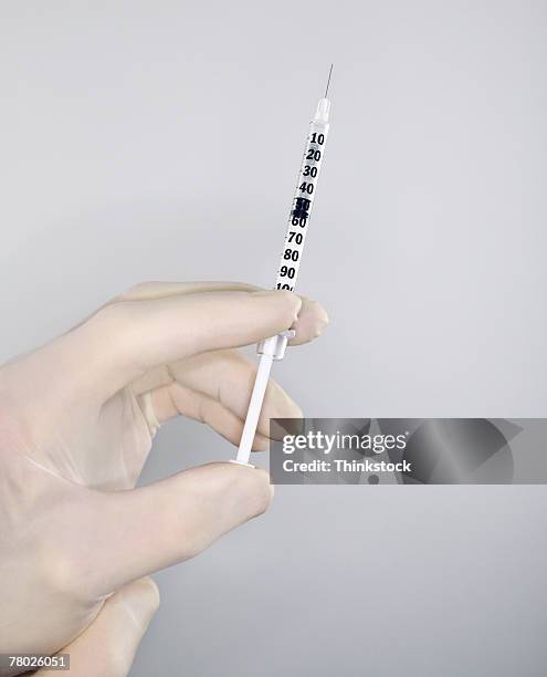 a gloved hand checks a syringe - box of surgical gloves stock pictures, royalty-free photos & images