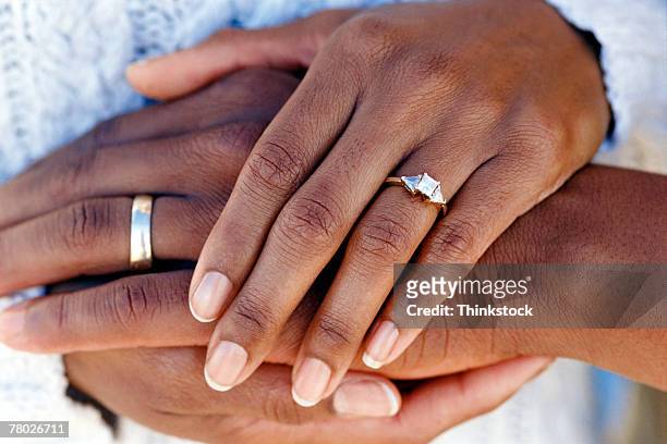 hands of married couple wearing wedding rings - ehering stock-fotos und bilder