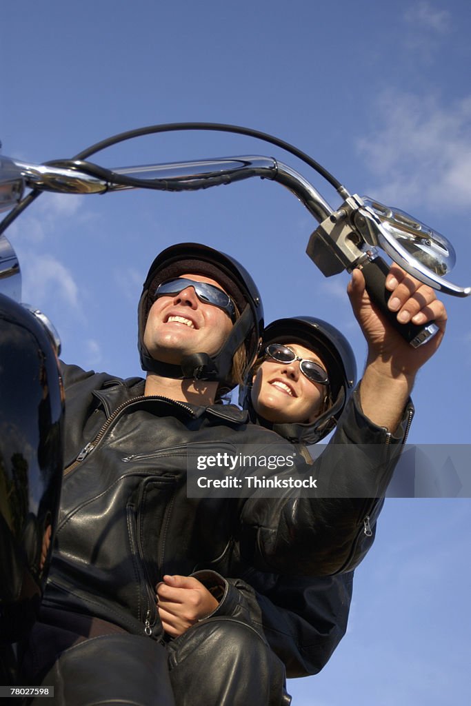 Low angle looking up to a couple sitting on their motorcycle ready to ride