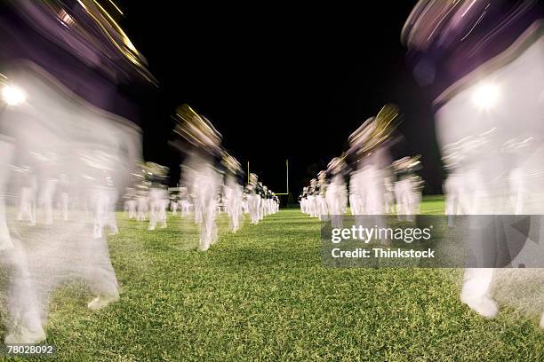 low angle motion blurred image of a band marching past the viewer. - marching stock pictures, royalty-free photos & images