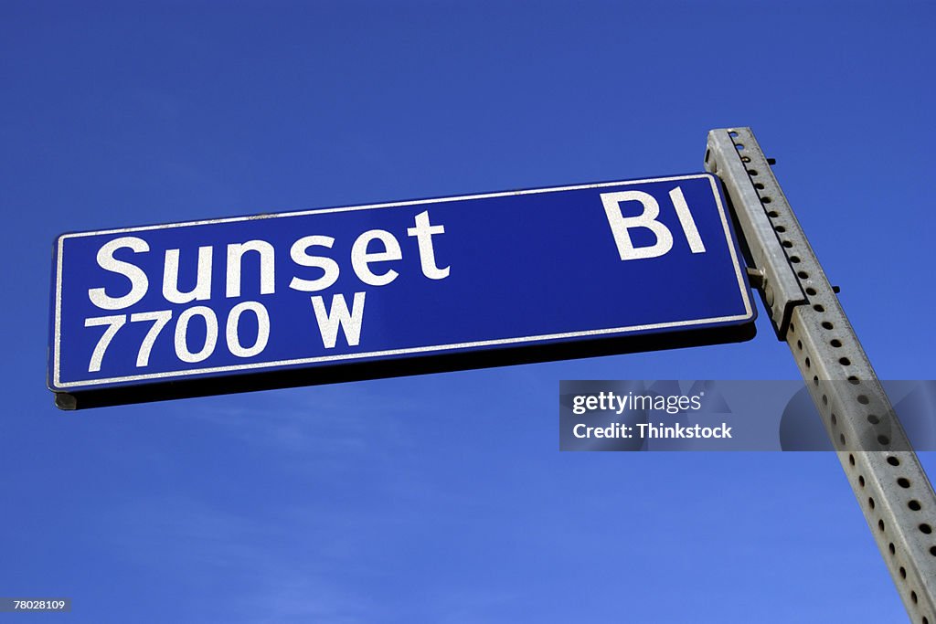 Sunset Boulevard sign against a blue sky from a low angle.