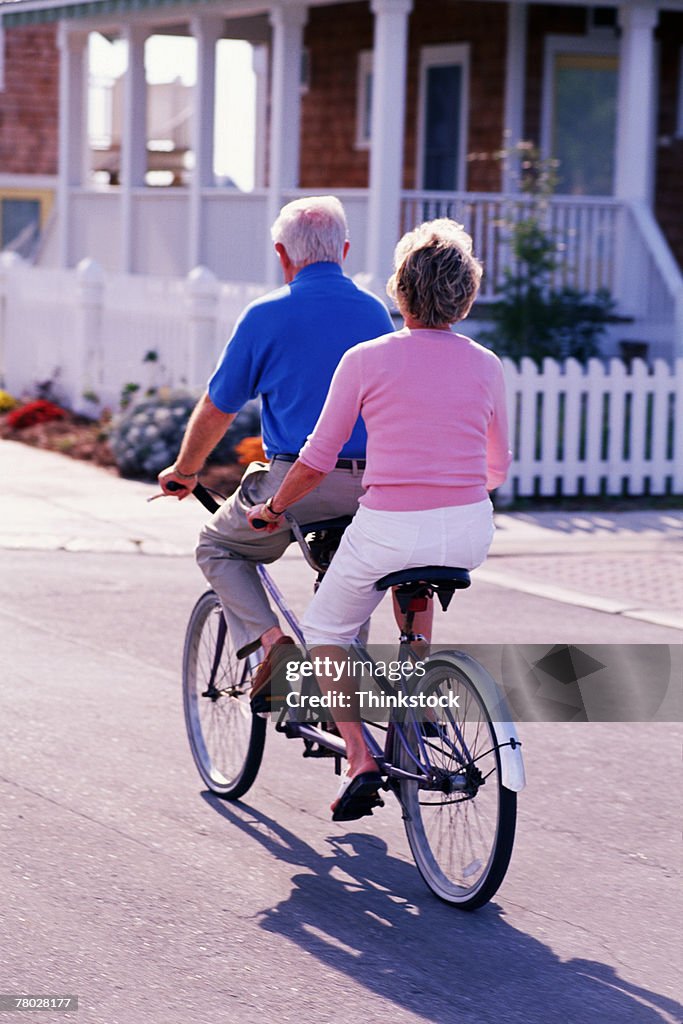 Couple riding tandem bicycle