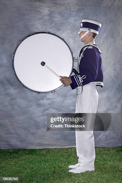 side view of a band member with a bass drum ready to play. - bass drum stock pictures, royalty-free photos & images