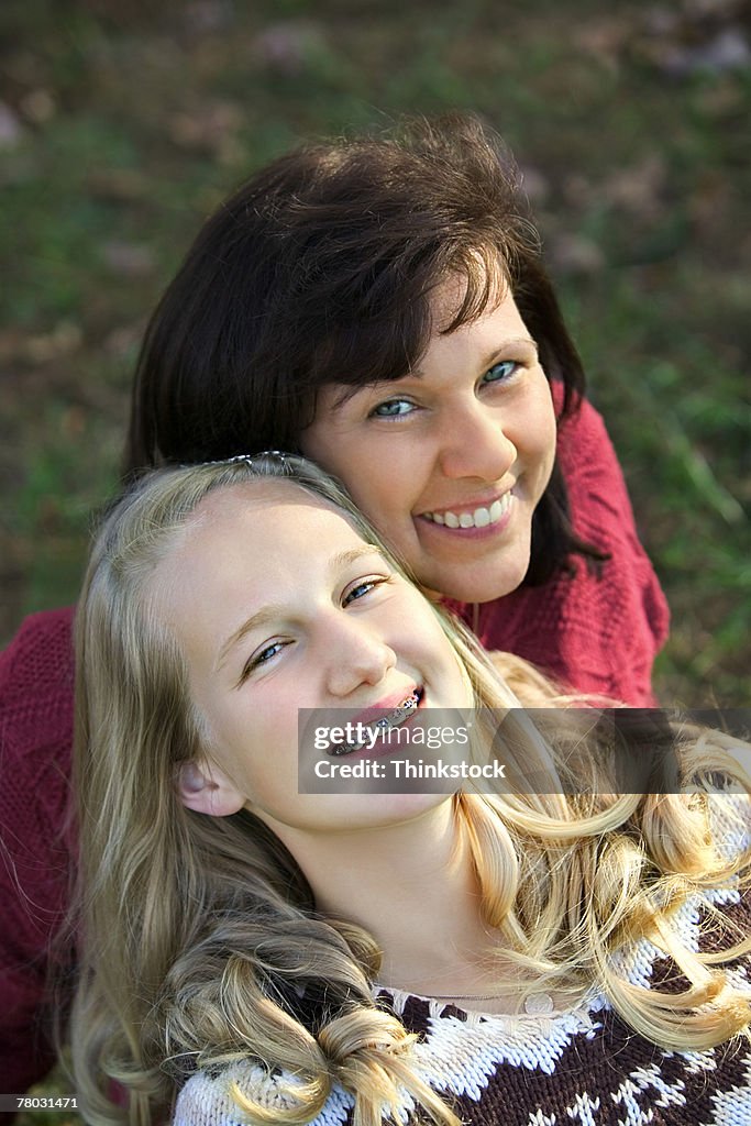 High angle portrait of a mother and daughter smiling up to the viewer.