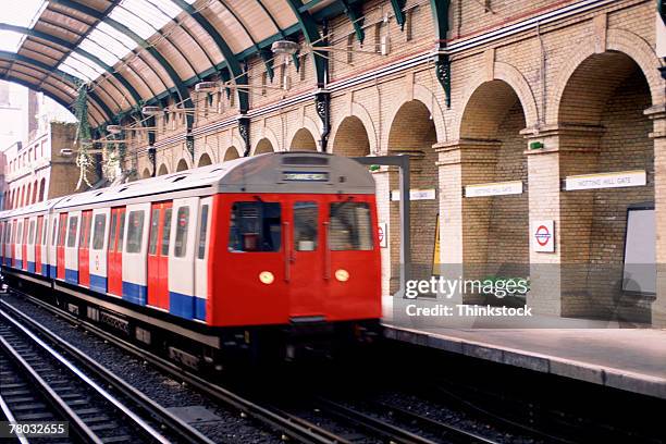 a train arriving at notting hill gate in the underground of london, england. - london underground train stockfoto's en -beelden