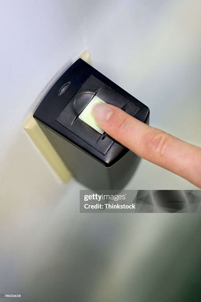 Close-up of a woman's finger on a fingerprint scanner for security system