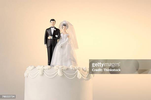 the top of a wedding cake with a miniature bride and groom cake topper - wedding cake figurine stock-fotos und bilder