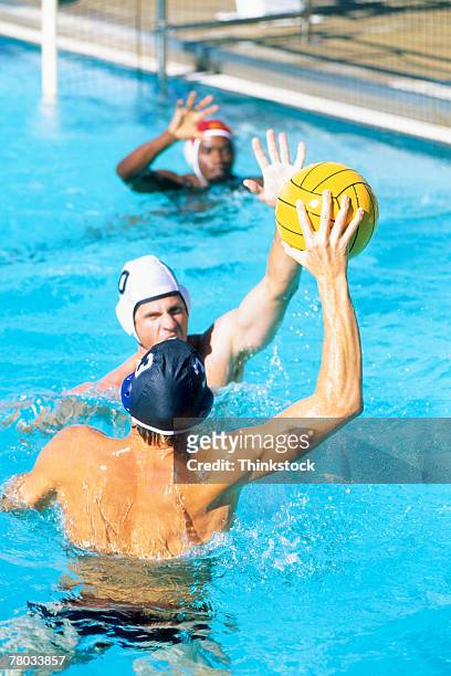 a player tries to pass the ball while playing water polo - male throwing water polo ball stockfoto's en -beelden