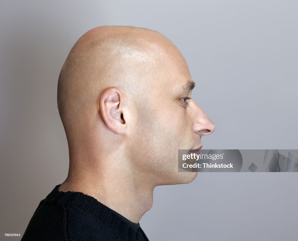 Profile headshot of a bald man with his eyes closed