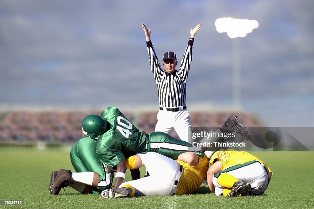 Referee signaling touchdown during football game