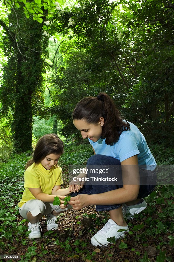 Mother and daughter looking at leaf together