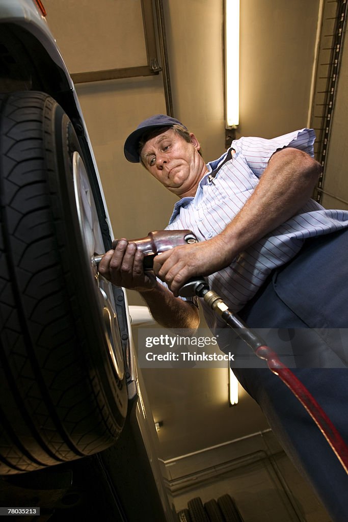 Mechanic tightening lug nuts on car tire