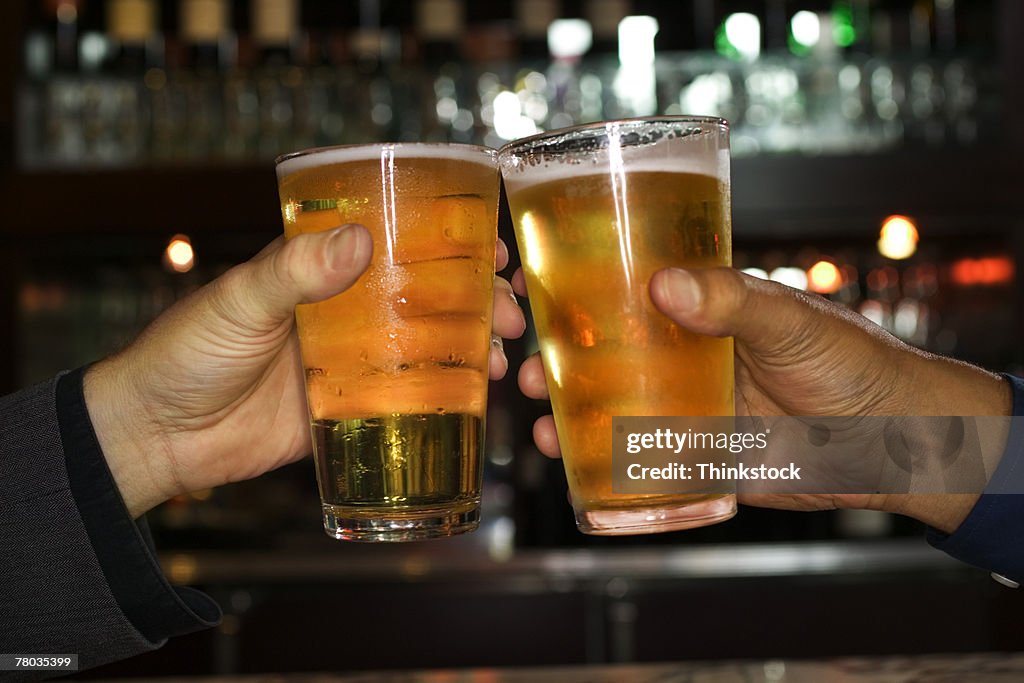 Hands of men toasting with beer