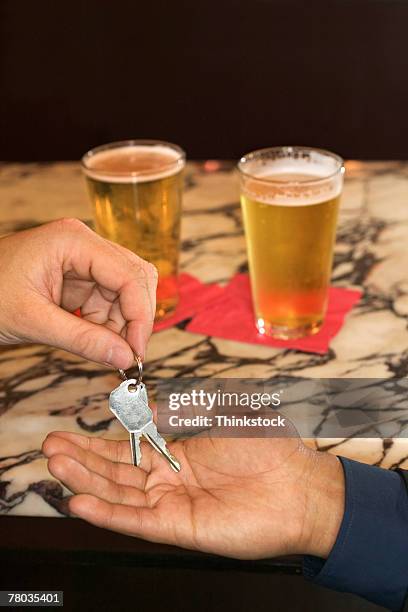 hand of man giving car keys to designated driver - bob stockfoto's en -beelden