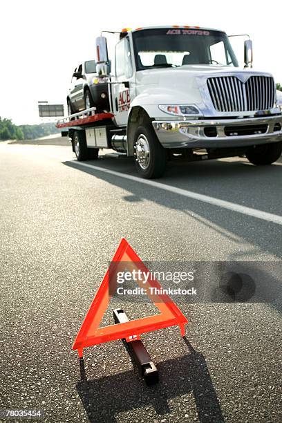 safety triangle and tow truck on highway - aa stock pictures, royalty-free photos & images