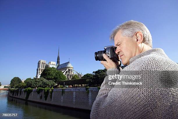 man taking picture of notre dame cathedral, paris - profile shoot of actor aradhya taing stockfoto's en -beelden