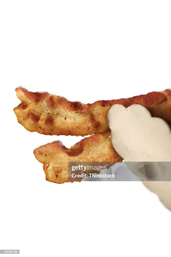Tongs Holding Bacon High-Res Stock Photo - Getty Images