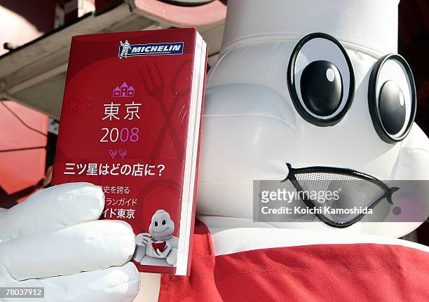 Michelin mascot displays the Michelin Guide Tokyo 2008 upon praying for the success of the guide book at Kanda Shrine on November 21, 2007 in Tokyo,...