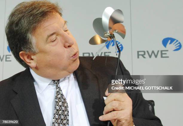 Juergen Grossmann, chief executive of German energy group RWE, blows a small windmill during a press conference 21 November 2007 in Essen, western...