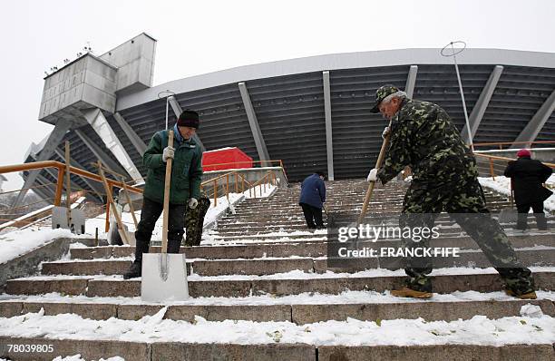 Workers remove snow from the steps of the Olympic Stadium entrance, 21 November 2007 in Kiev, before the last qualifing match Ukraine vs. France of...