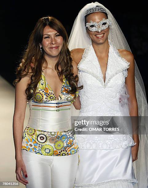 Peruvian designer Claudia Jimenez poses with one of her models at the end of the presentation of her collection during the first day of Fashionweek...