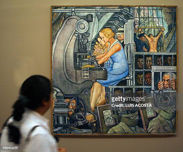Journalist stands next to the piece Number 12, which his one of the parts of the mural paint "La Nueva Libertad" created by Mexican artist Diego...