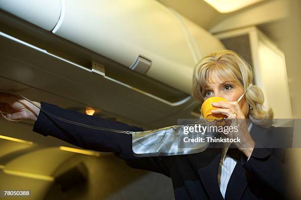 flight attendant with an oxygen mask - oxygen mask stock-fotos und bilder