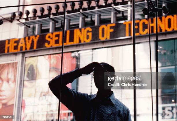 Bystander looks into the window of the Nasdaq MarketSite near the close of trading April 12, 2000 in New York City. The Nasdaq lost 286.69 points to...