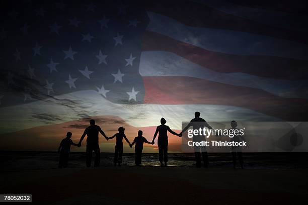 people holding hands with american flag - patriots stock pictures, royalty-free photos & images