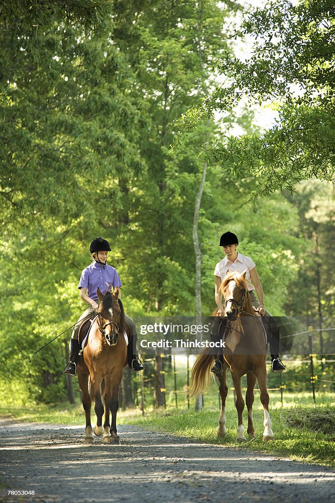 Mother and daughter riding horses