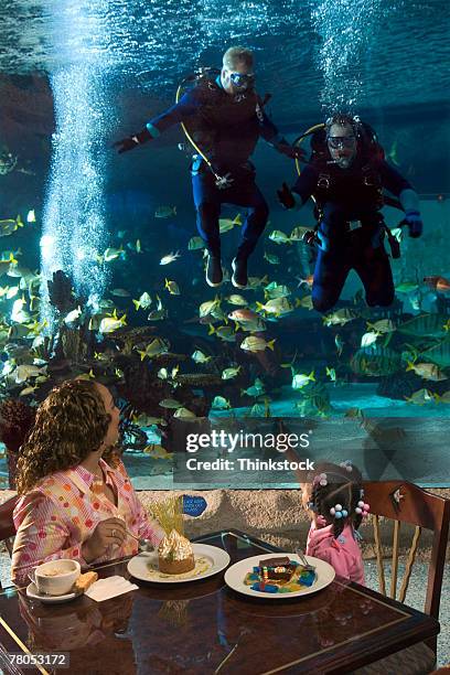 visitors eating in restaurant inside aquarium - scuba diving girl stock-fotos und bilder