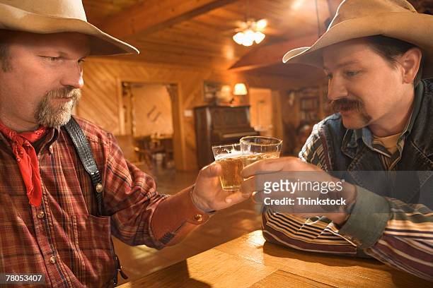 cowboys drinking whiskey in saloon - hair color saloon stock pictures, royalty-free photos & images