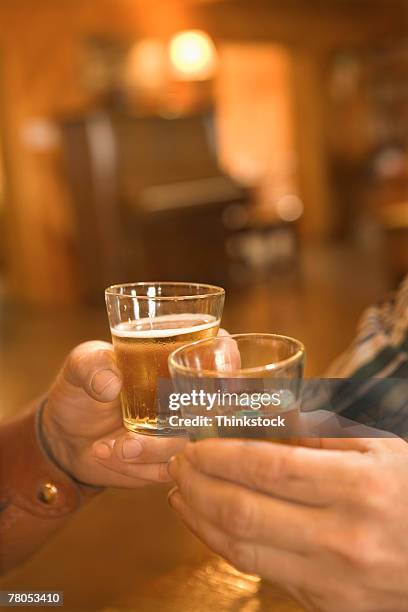 hands toasting whiskey in saloon - man acting being shot stock-fotos und bilder