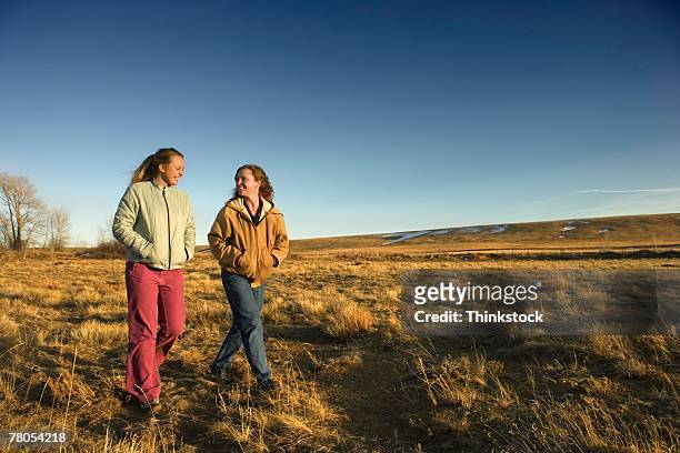 mother and daughter walking in field - laramie foto e immagini stock