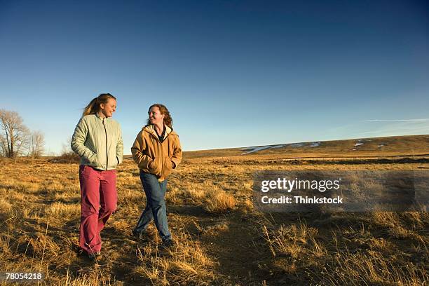 mother and daughter walking in field - laramie stock pictures, royalty-free photos & images