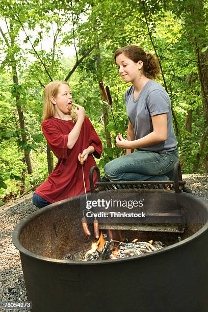 girls at campfire with burnt hot dog - weenie roast stock pictures, royalty-free photos & images