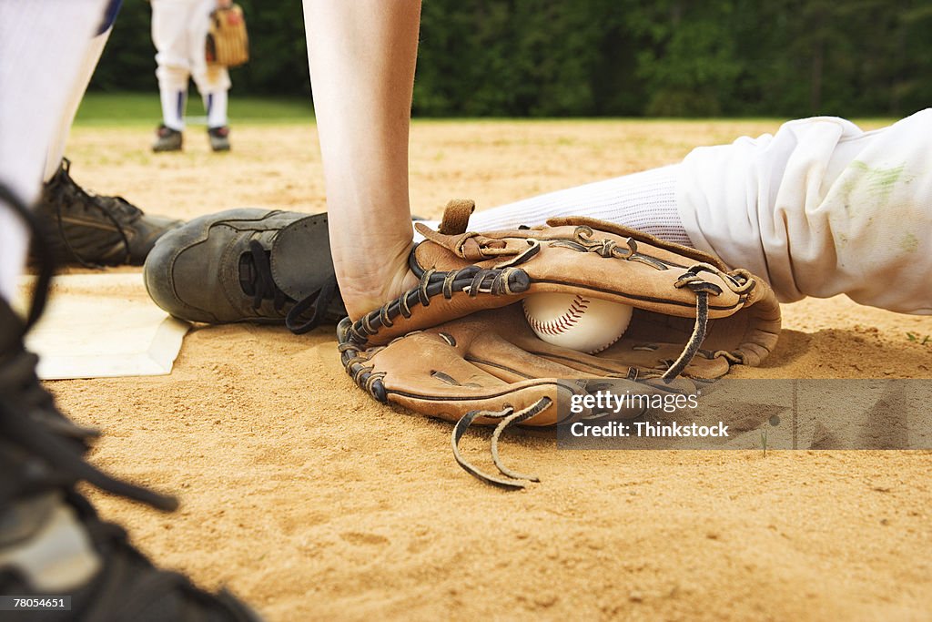 Glove of baseball player tagging runner out, maybe safe