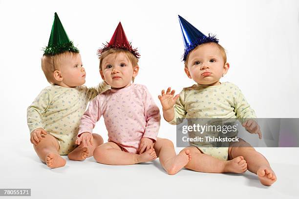 babies in party hats - triplet girls stock pictures, royalty-free photos & images