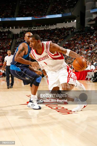 Tracy McGrady of the Houston Rockets dribbles the ball past Erick Dampier of the Dallas Mavericks on November 21, 2007 at the Toyota Center in...