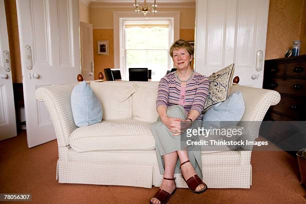 mature woman in living room - t 55 stock-fotos und bilder