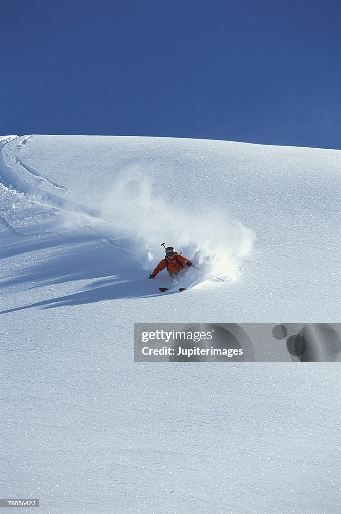 Person skiing down snow covered mountain