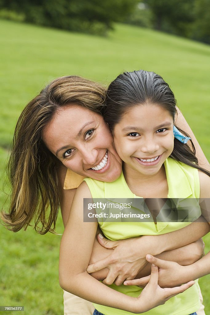 Mother embracing daughter in park